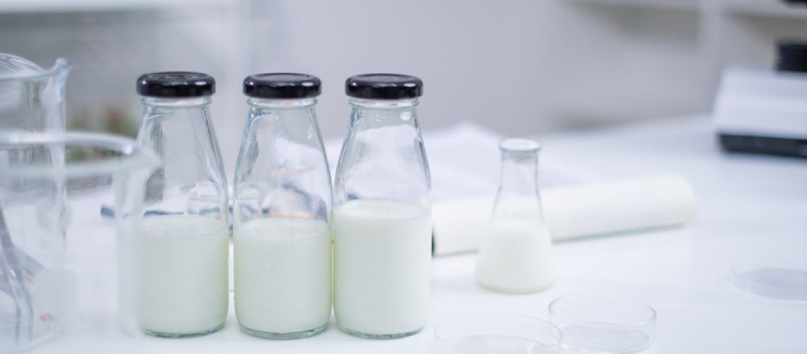 Bottle of a sample milk. Concept of nutrition, lactose, protein, bacteria, fat and glucose laboratory. Dairy milk test. Nutritionist is checking and analyze the quality of factory milk product